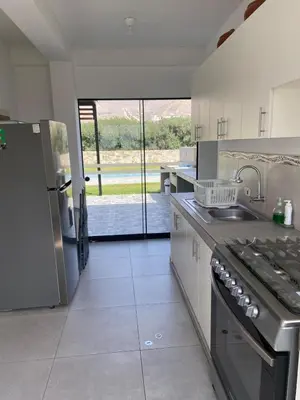 a kitchen with a sink and a stove top oven at Casa de Campo en Cieneguilla in Hacienda Cienguilla