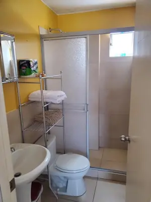 a bathroom with a shower and a toilet and a sink at Edificio Parque Suarez - San Miguel in Lima
