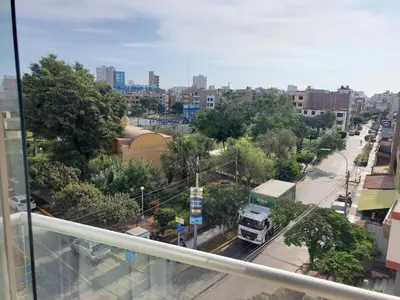 a truck driving down a street in a city at Edificio Parque Suarez - San Miguel in Lima
