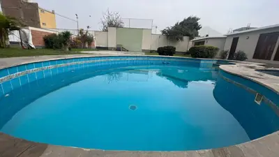 a large blue swimming pool in a yard at Casa Grande de Campo en Huachipa in Lima