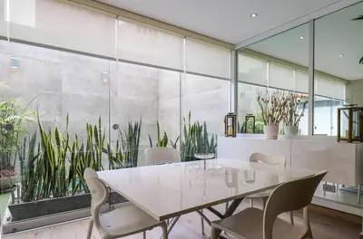 a dining room with a table and chairs and plants at Mimosas 161 by Wynwood House in Lima