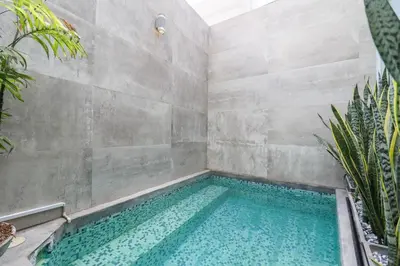a swimming pool in a room with a concrete wall at Mimosas 161 by Wynwood House in Lima