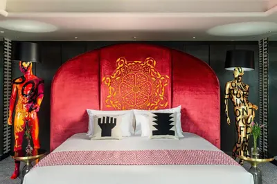 a bedroom with a large bed with a red headboard at Nhow Lima in Lima