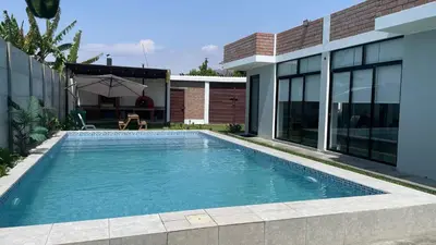 a swimming pool in front of a house at Casa de Campo Aucallama in Huaral