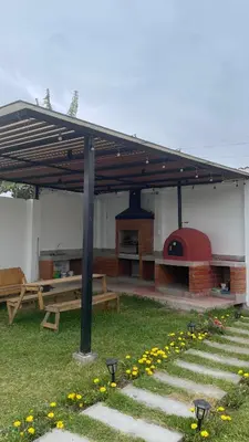a pavilion with a picnic table and a pizza oven at Casa de Campo Aucallama in Huaral