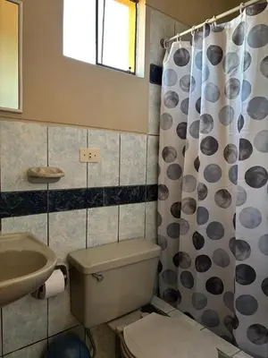 a bathroom with a toilet and a sink at Hotel Alicia in El Puente