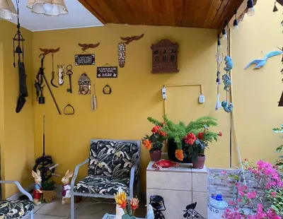 a room with a chair and a wall with decorations at Hotel Alicia in El Puente
