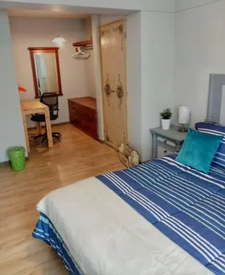 a bedroom with a blue and white bed and a desk at Bonito y Moderno 1 o 2 dormitorios in Lima
