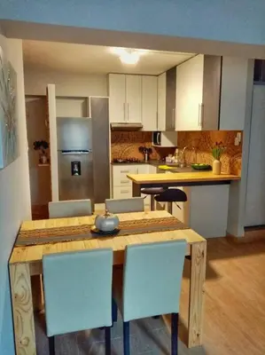 a kitchen with a wooden table and chairs at Bonito y Moderno 1 o 2 dormitorios in Lima