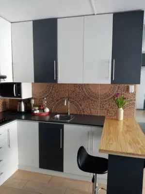 a kitchen with black and white cabinets and a wooden table at Bonito y Moderno 1 o 2 dormitorios in Lima