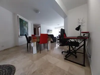 a living room with a table and red chairs at Fantastic Location in Miraflores in Perú in Lima