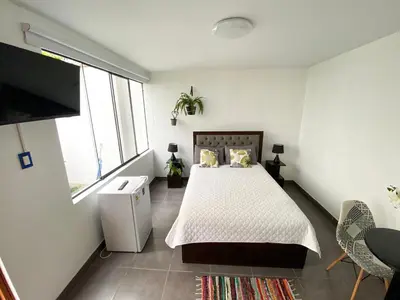 a bedroom with a bed and a large window at Hermosa habitación independiente cerca a Miraflores in Lima