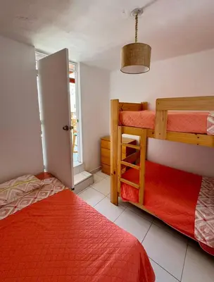 a bedroom with two bunk beds and a window at Surfer Hostel El Quilla Punta Hermosa in Punta Hermosa