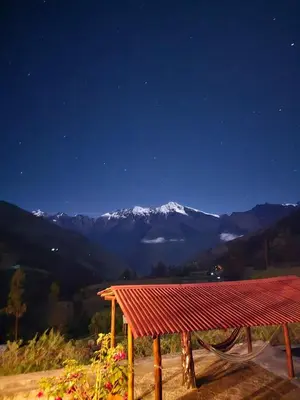 a table with a view of a mountain at night at CASA de SALCANTAY , Choquequirao in Cachora
