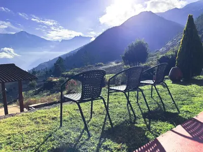 two chairs sitting on top of a field with mountains at CASA de SALCANTAY , Choquequirao in Cachora