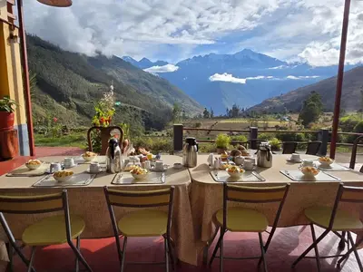 a dining table with a view of a mountain at CASA de SALCANTAY , Choquequirao in Cachora