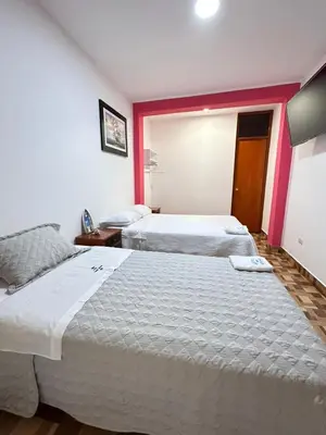 two beds in a room with red and white walls at Hotel Atenas City in San Andrés