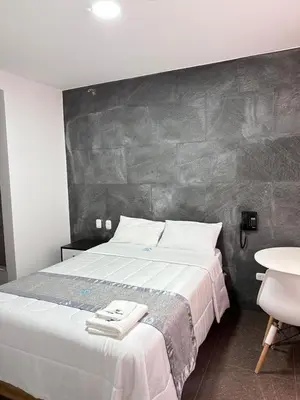 a bedroom with a large bed with a gray wall at Hotel Atenas City in San Andrés