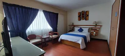 a bedroom with a bed and a table and a window at Blue Star Hotel in Lima