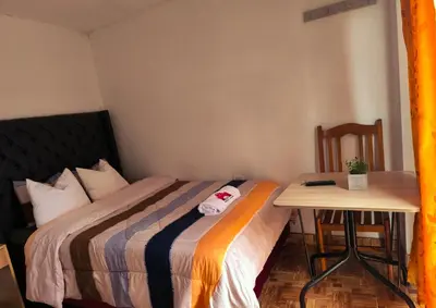 a small bedroom with a bed and a table at Aqquazul Hospedaje Ayacucho in Ayacucho