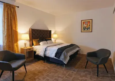 a bedroom with a bed and two chairs at Aqquazul Hospedaje Ayacucho in Ayacucho