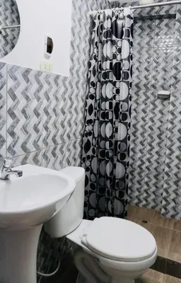a bathroom with a toilet and a shower curtain at Aqquazul Hospedaje Ayacucho in Ayacucho