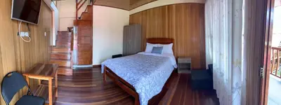 a small bedroom with a bed and a staircase at DCampos Lodge in Oxapampa