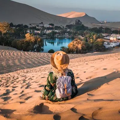 a person sitting in the sand with a hat at Adanny Tours Peru in Lima