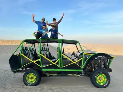 a group of people standing on the back of a jeep in the desert at Adanny Tours Peru in Lima