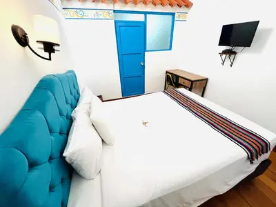 a bedroom with a large bed and a tv at Rojas Plaza Boutique in Cusco