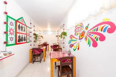 a room with tables and chairs and paintings on the wall at Retablo Boutique Hotel in Ayacucho