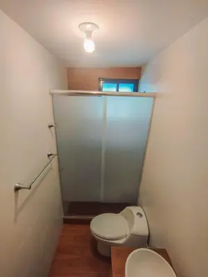 a bathroom with a toilet and a glass door at Cusco Central Complete Apartment in Cusco