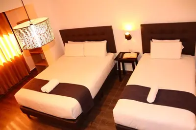 a hotel room with two beds and a lamp at Tikal Inn Machupicchu in Machu Picchu