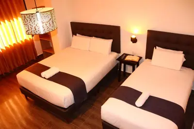 a hotel room with two beds and a lamp at Tikal Inn Machupicchu in Machu Picchu