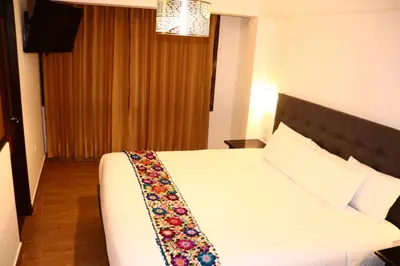 a hotel room with a bed with a flower tie on it at Tikal Inn Machupicchu in Machu Picchu