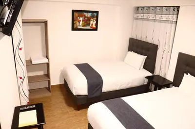 a hotel room with two beds and a tv at Tikal Inn Machupicchu in Machu Picchu