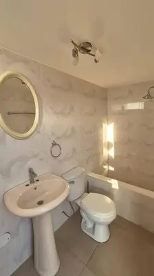 a bathroom with a sink and a toilet and a mirror at Apartamento duplex a 1 cuadra de Playa Naplo in Pucusana