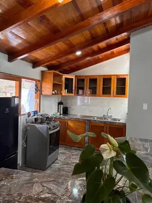 a kitchen with wooden cabinets and a stove top oven at Rumiwasi Inn Apartament in Ollantaytambo