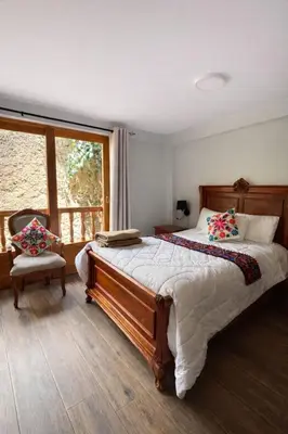 a bedroom with a large bed and a window at Rumiwasi Inn Apartament in Ollantaytambo