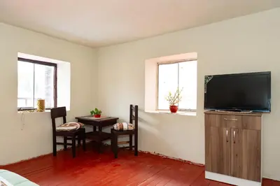 a living room with a tv and a table and chairs at Munay Tika house in Cusco