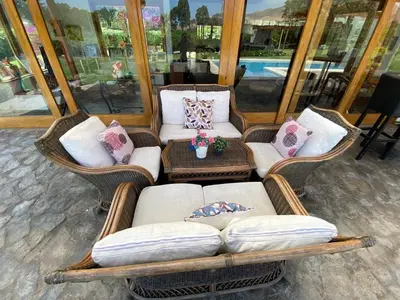 a group of chairs and couches with pillows at Alquiler Casa de Campo Asia Cañete in San Andrés
