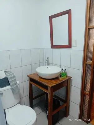 a bathroom with a sink and a toilet and a mirror at Casa Las Palmeras in Oxapampa