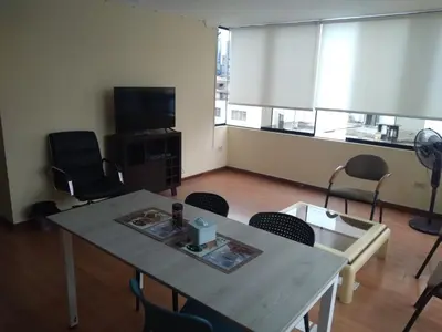 a room with a table and chairs and a television at Departamento Centro Financiero San isidro in Lima