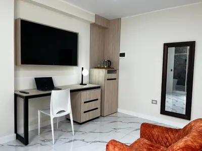 a room with a desk with a laptop and a tv at Residencial Mar Caribe in Lima