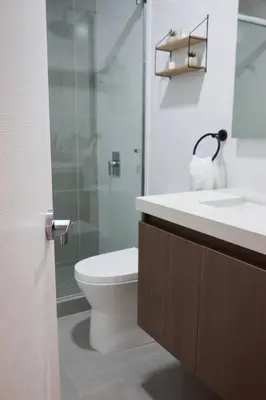 a bathroom with a toilet and a glass shower at Departamento de Estreno Lima Miraflores in Lima