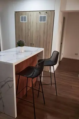 a kitchen with two chairs and a counter with a sink at Departamento de Estreno Lima Miraflores in Lima