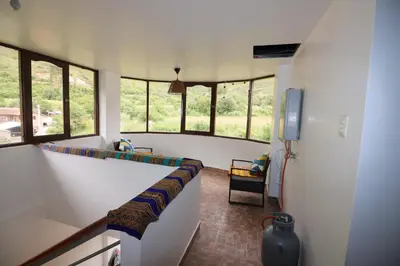 a room with a hallway with windows and a table at Casa de Campo Apu San Isidro in Urubamba