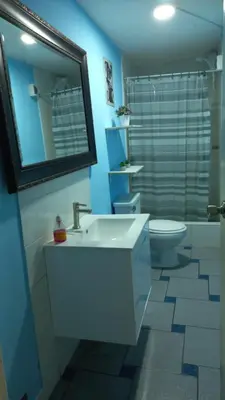 a bathroom with a sink and a toilet and a mirror at Lopez House Family Aparment in Lima