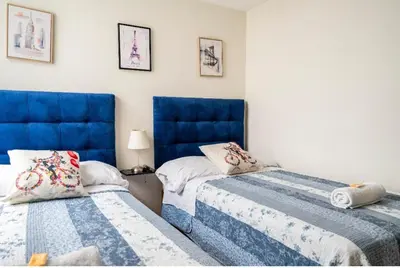 two beds in a room with blue headboards at Lopez House Family Aparment in Lima