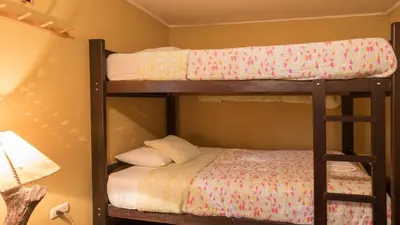 two bunk beds in a room with a bed at Beraja Family Hostel in Lima